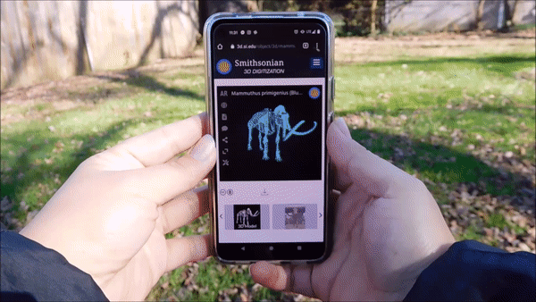 "person using smartphone to put AR mammoth in a yard"